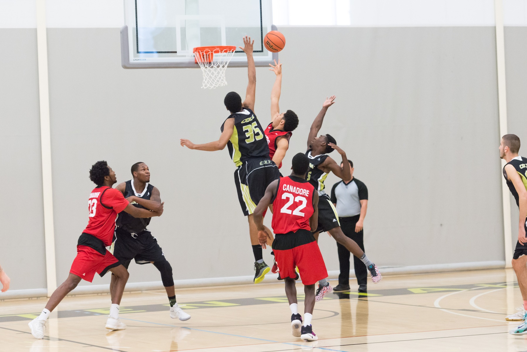 Colts men's basketball player Malcolm Jackson attempts to block the opposing Canadore player.