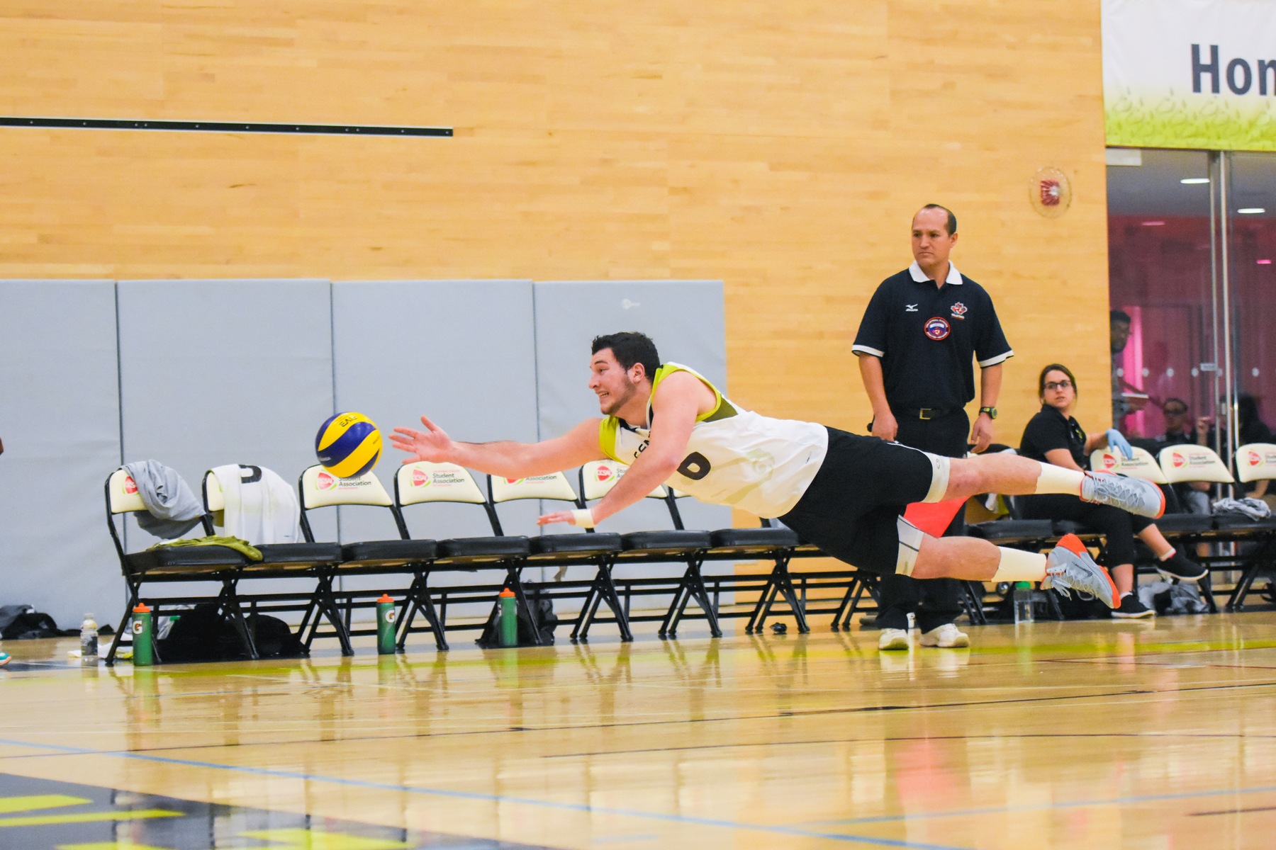 Colts men's volleyball player Ethan Peter tries to dive for the ball.