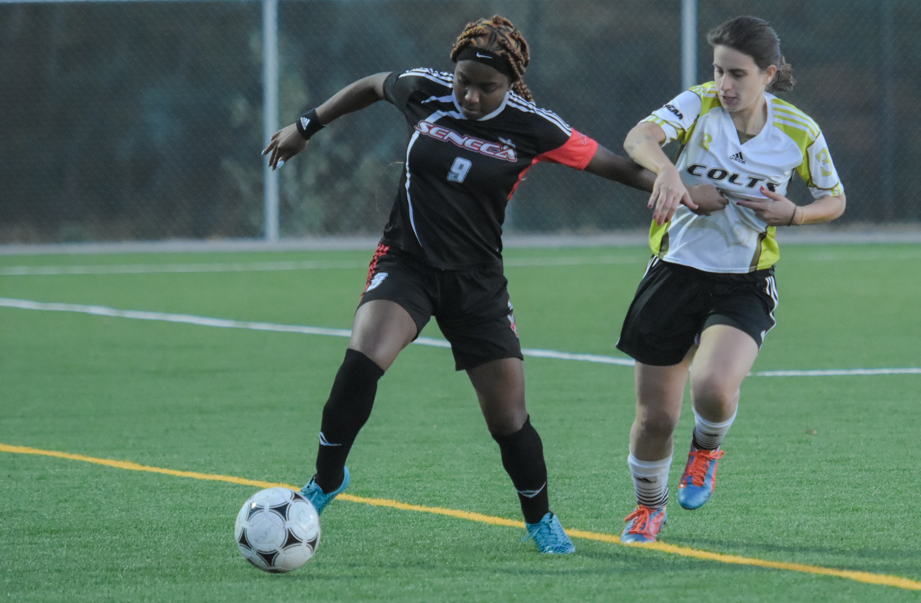 Seneca Sting defender Kaylia Keen and Centennial Colts midfielder Lais Rios fight for the ball during the second half of Centennial's 4-0 loss to Seneca at AWC Colts Pitch.